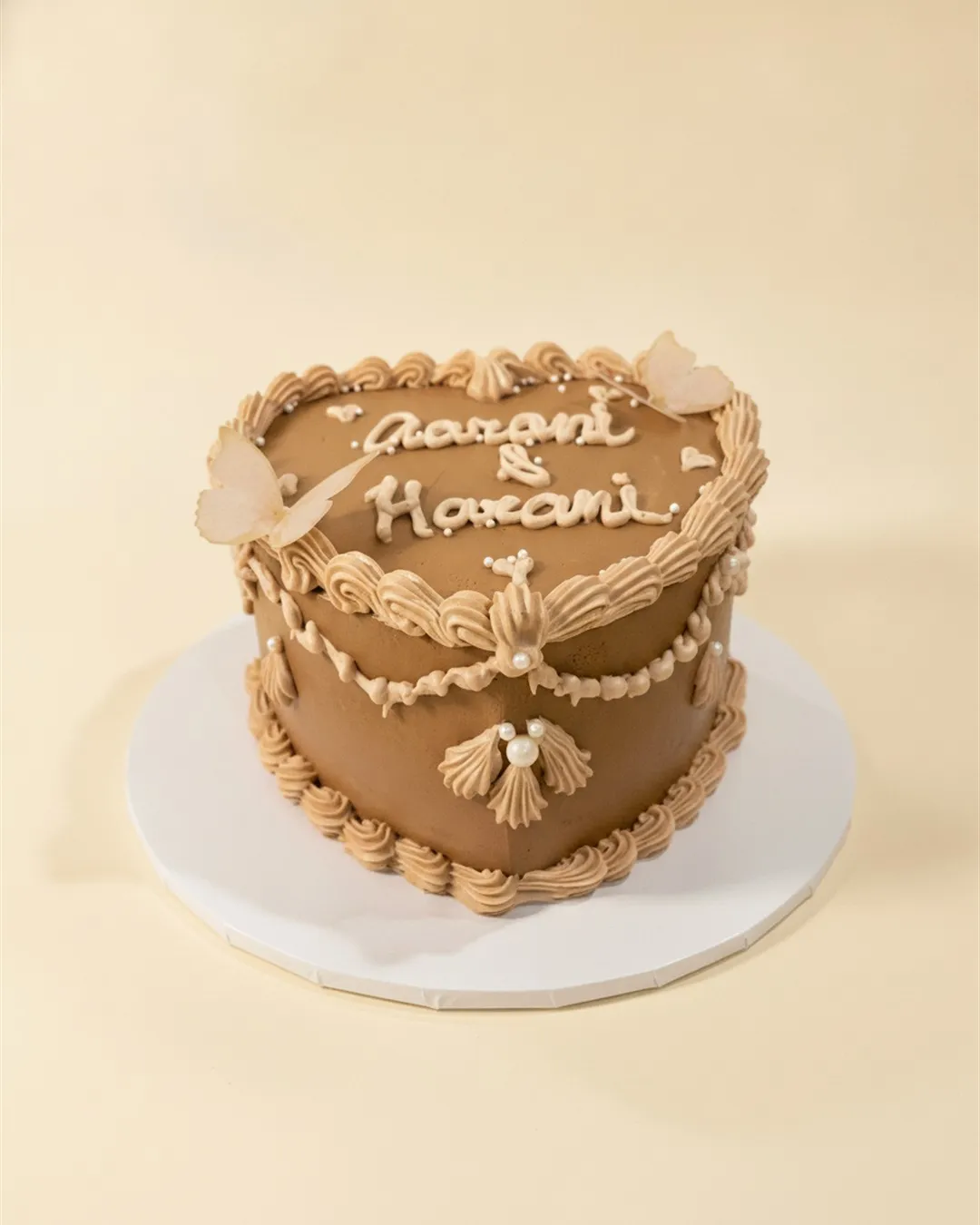 Caramel heart-shaped cake with vintage piping, sugar doves and script lettering